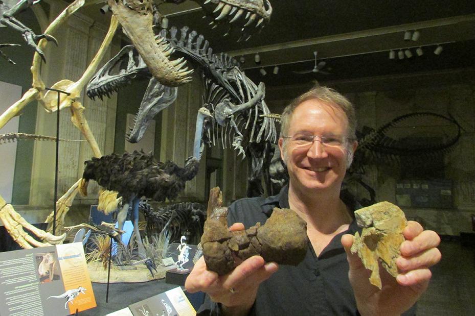 Professor Thomas Carr (biology, paleontology) holds a portion of a shin and ankle of a T. rex.